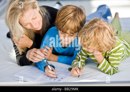 Woman helping her sons in their homework Stock Photo