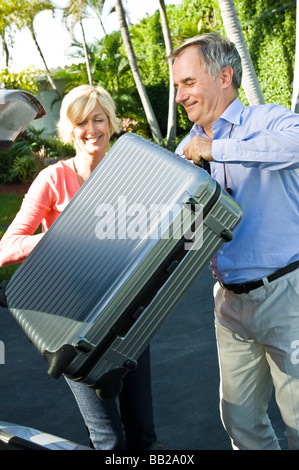 People Loading Luggage Couple loading vehicle trunk with luggage while going on marriage ...