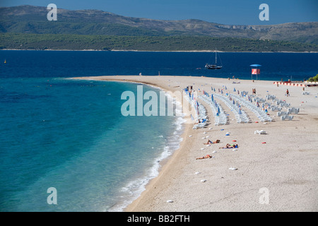 Traveling Croatia; The famous white sand beach, Zlatni Rat, on Brac Island, is lined with lounge chairs and sunbathers. Stock Photo