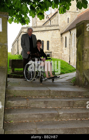 Wheelchair user and carer at the top of a flight of steps Stock Photo