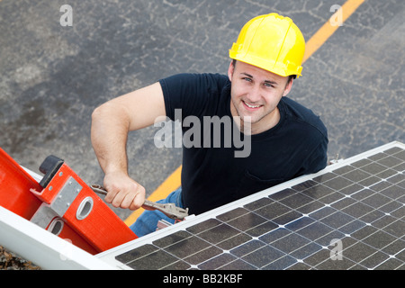 Young electrician on a ladder installing solar panels  Stock Photo