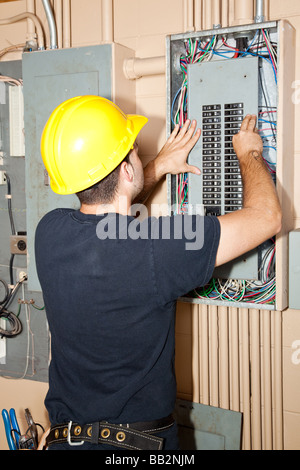 Electrician repairing circuit breakers in industrial electric panel  Stock Photo