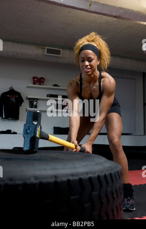fit girl throwing a sludge hammer for a core workout Stock Photo