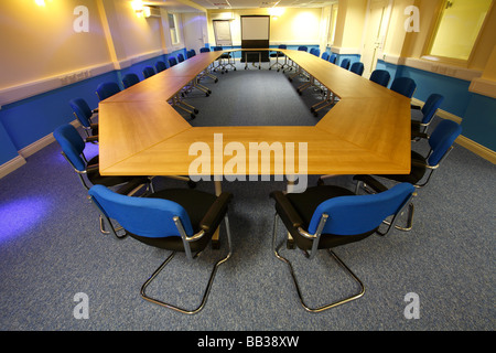 Large empty meeting room with blue chairs and wooden table Stock Photo