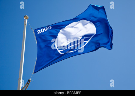 Blue flag flying to indicate beach water quality standards UK Stock Photo