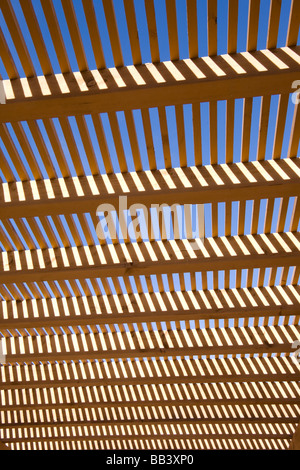 NA, USA, New Mexico, Santa Fe, Museum Hill, MilnerPlaza, Sunlight filtering through wooden lattice structure Stock Photo