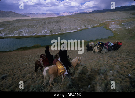 Horsemen drive loaded yaks through the steppe in the Little Pamirs, Wakhan Corridor, Badakshan Stock Photo