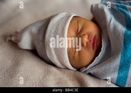 A two-day-old baby girl lays swaddled in a hospital blanket before leaving with her parents Stock Photo