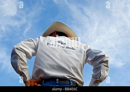 Rodeo cowboy surveys the field in the wide open spaces of the southwest United States with a deep blue sky framing his bright we Stock Photo