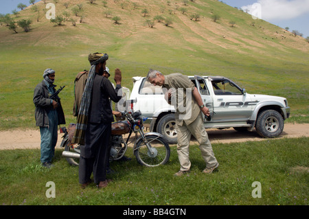 A wildlife biologist conducting a wildlife survey in the region, greets a leader of the Kuchi nomads, in the grasslands  near th Stock Photo