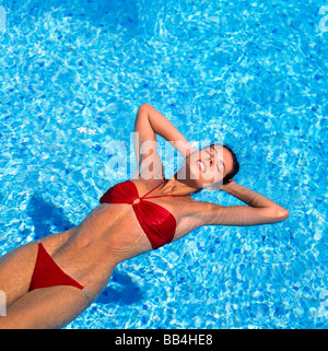 YOUNG WOMAN FLOATING IN SWIMMING POOL GUADELOUPE FRENCH WEST INDIES