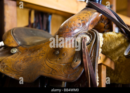 The tack room showing saddles and cowboy boots on The Hideout Ranch in Shell Wyoming. Stock Photo