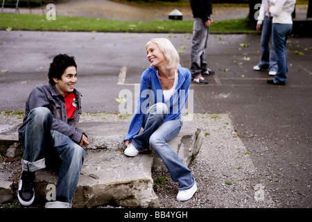 teenager group smiling sitting in park Stock Photo