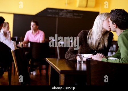young couple kissing in a cafe