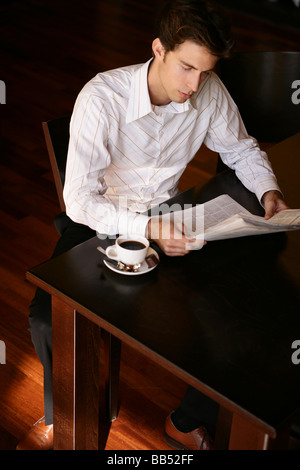 young man with a newspaper in cafe Stock Photo