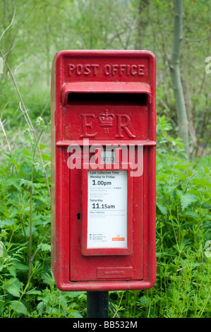 E R Post Box Symbol Red British post box with 'ER' symbol in front of a stone building with ...