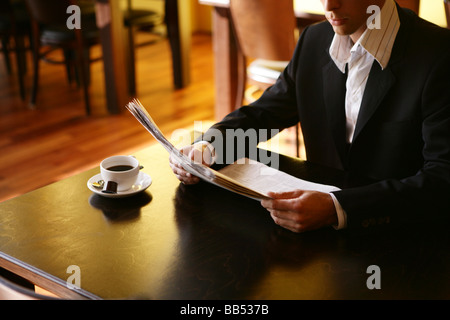 young man with a newspaper in cafe Stock Photo