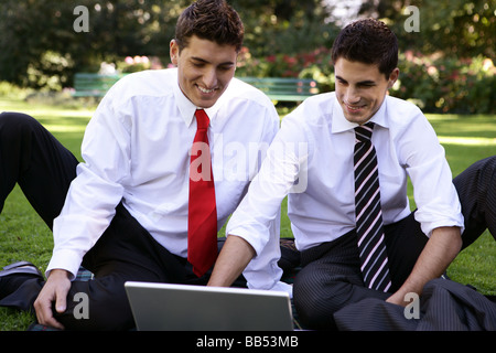 two business men with laptop in a park Stock Photo