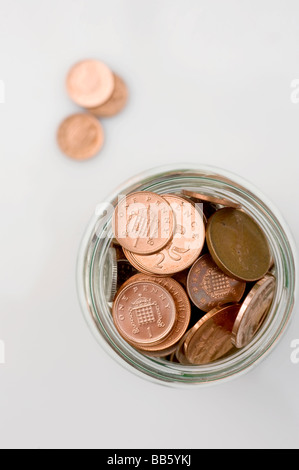 Loose change: a jam jar overflowing with British coins. Picture by Jim Holden. Stock Photo