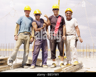 Hispanic workers standing on construction site Stock Photo