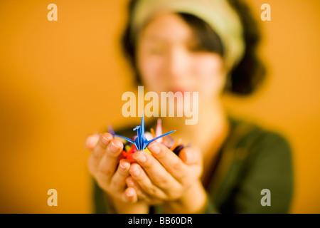 Japanese woman holding origami bird Stock Photo