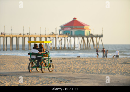 Tourists on a Pedal Mobile in front of the pier, Huntington Beach CA Stock Photo