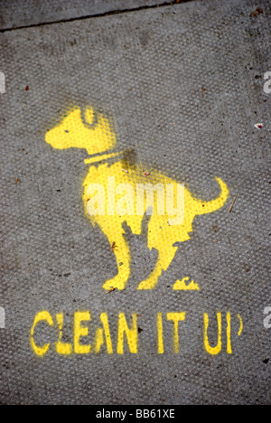 local council yellow stencilled image of defecating dog on pavement with phrase clean it up, in chiswick, west london, england Stock Photo