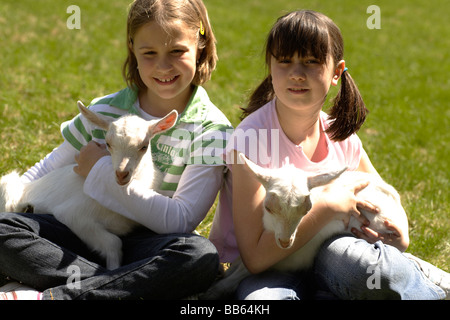 girl holding a goat in his arms on the meadow Stock Photo