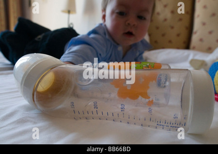 Babies bottle and 6 month old baby Stock Photo