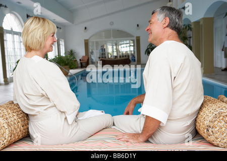 Middle Aged Couple Relaxing By Swimming Pool Stock Photo