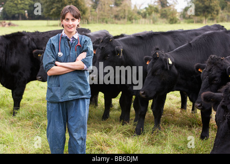 Portrait Of Vet In Field With Cattle Stock Photo