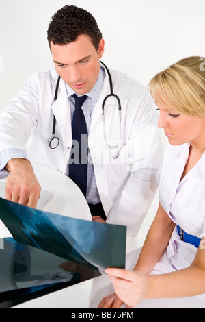 A male doctor examining an X ray with his female nursing colleague Stock Photo