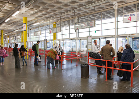People waiting for bus in coach station Swansea Wales UK Stock Photo