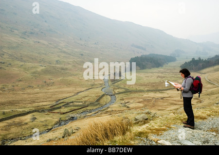 Female walker consulting map in Grisedale, Lake District National Park, England. Stock Photo