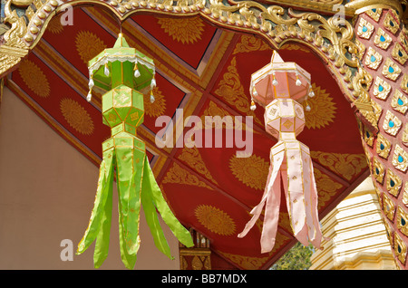 Brightly coloured festival lanterns hang from the eaves of a Buddhist temple in Chiang Mai Thailand Stock Photo