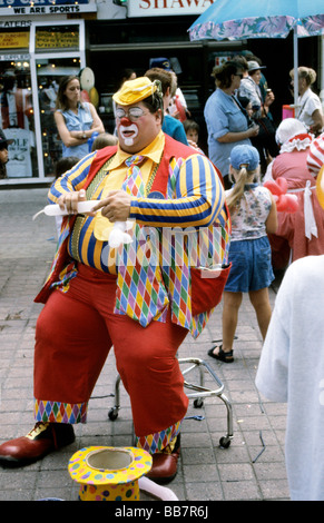 Large clown sitting shaping balloon animal Stock Photo