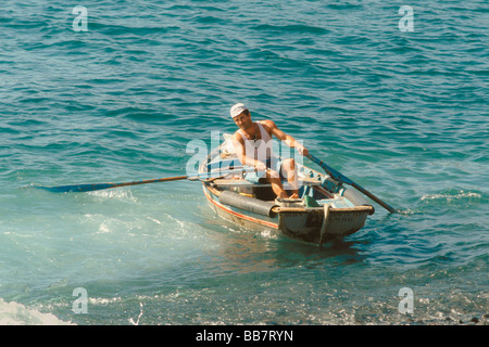 A man coming ashore in a canoa class fishing boat at Funchal Madeira Portugal Europe Stock Photo