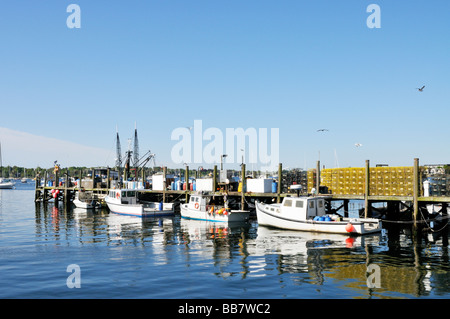 Lobster boats docked at pier in Newport Harbor Rhode Island with seagulls and lobster traps stacked on pier USA. Stock Photo