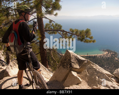 A mountain biker enjoys a view of Lake Tahoe from the Great Flume Trail near Spooner Summit . Stock Photo