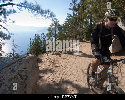 A mountain biker enjoys a view of Lake Tahoe from the Great Flume Trail near Spooner Summit . Stock Photo