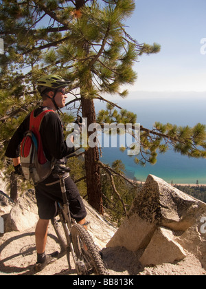 A mountain biker enjoys a view of Lake Tahoe from the Great Flume Trail near Spooner Summit . Stock Photo