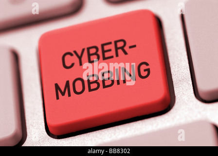 Red button on a computer keyboard with the label Cyber-mobbing Stock Photo