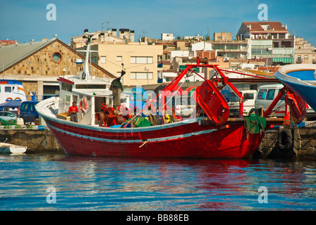 Red fishing boat with fisherman in the harbor of Palamos Catalonia Spain Stock Photo