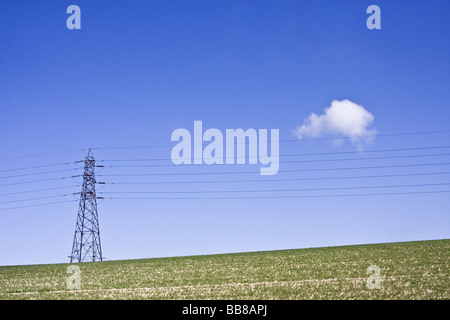 Electricity Pylon & Cables in a Field, Against a Blue Sky. Stock Photo