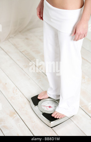 Cut out of young woman standing on a scale Stock Photo