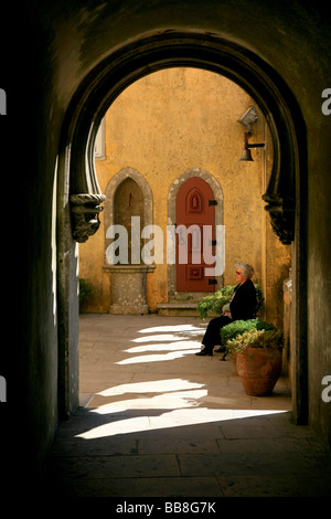 Elderly lady relaxing on a bench in the courtyard at the Pena National Palace Stock Photo