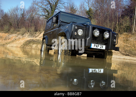 A Landrover Defender driving through a flood on an off road exercise Stock Photo