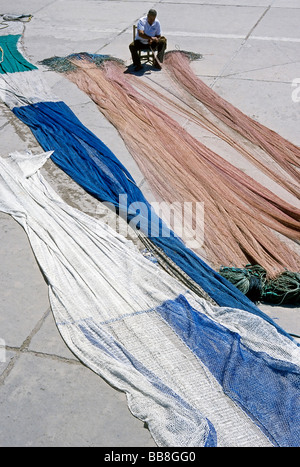 Fisherman repairing fishing nets, Puerto de Sòller, Majorca, Balearic Islands, Spain, Europe Stock Photo