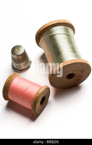 two spools of thread and a thimble on white Stock Photo