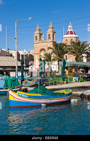 Traditional Maltese fishing boat, called Luzzu, in front of the Church of Our Lady of Pompeii, port of Marsaxlokk, Malta, Europe Stock Photo